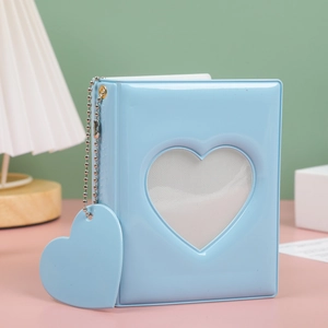 Light blue mini photo album with heart-shaped cutout and matching heart charm pendant