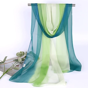 Close-up of lightweight teal and lime green gradient chiffon scarf hanging for display