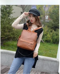 Outdoor shot of a caramel brown leather backpack showing stylish side pockets and buckle details