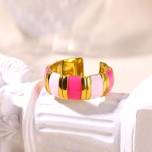 Detail of pink and white enamel 18K gold-plated stainless steel open ring on a stone pedestal