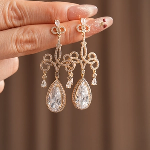 Gros plan de boucles d'oreilles gouttes dorées de luxe avec zircons scintillants