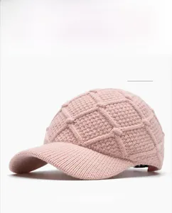 Close-up of pink knitted baseball cap showing detailed diamond pattern and ribbed texture
