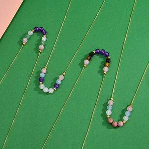 Close-up of gold beaded necklaces with colorful amethyst and rose quartz stones