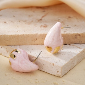 Pink marble texture teardrop earrings with gold base on minimalist stone stand