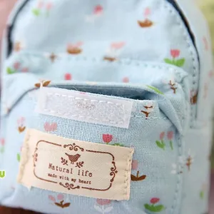 Macro detail of mini floral canvas backpack with blue tulip pattern and natural life label