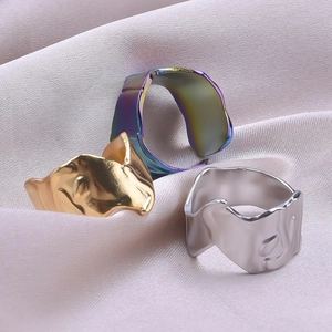 Macro detail of irregular wave textured rings in gold, silver and iridescent finishes