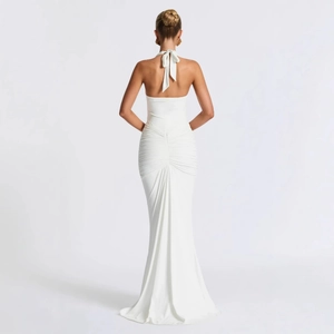 Elegant white backless halter mermaid dress featuring ruched details and a sleek silhouette