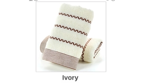 Close-up of creamy white thick cotton towels featuring textured wave and stripe patterns