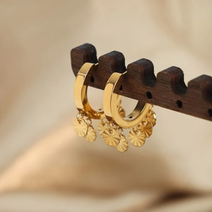 Boucles d'oreilles créoles dorées en U avec pendentifs disques rayés sur support bois