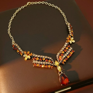 Nahaufnahme einer Vintage-Goldkette mit Kristallen auf einer edlen Leder-Schmuckschatulle