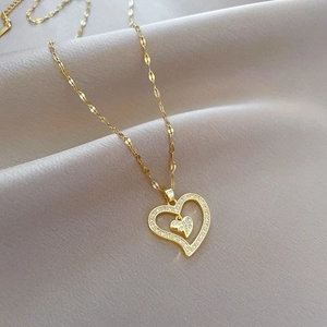 Detail of gold heart pendant with sparkling crystals on soft beige silk fabric