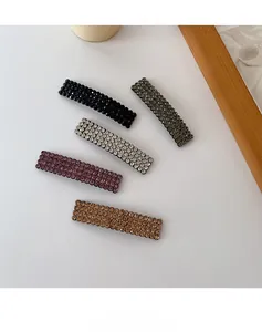 Close-up of five rhinestone rectangle hairpins in black, grey, and purple hues