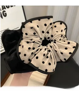 Close-up of oversized polka dot scrunchie and black hair tie with soft fabric pleats