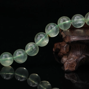 Bracelet en perles de préhnite vert clair naturel à texture translucide sur fond noir
