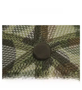Macro shot of breathable mesh knit texture and top button on a green outdoor sun hat
