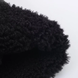 Detailed close-up of thick black faux fur texture on a fashion stand-collar jacket