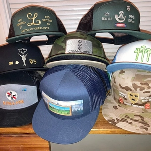 Detail of multi-colored mesh trucker hats with custom embroidery and vintage patches