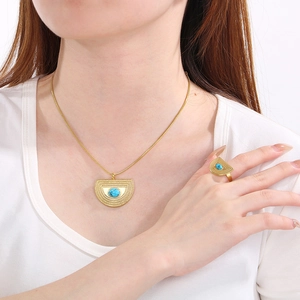 Elegante set collana e anello a ventaglio dorato con gemme blu indossato da modella