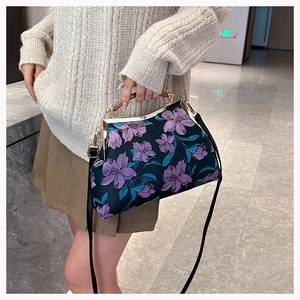 Detail of dark cheongsam handbag featuring purple floral embroidery and wooden handle