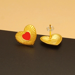 Macro detail of 925 silver heart stud earrings with red enamel and golden texture