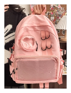 Detailed close-up of a pink nylon school backpack featuring mesh pockets and buckles