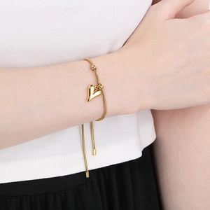 Elegant 18K gold plated heart charm snake bone bracelet for women on a model's wrist