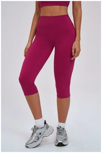 Detail of high waisted fuchsia brushed yoga capris with tummy control effect on model