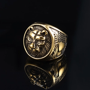 Detailed macro view of an antique gold lion head ring with intricate metallic engraving