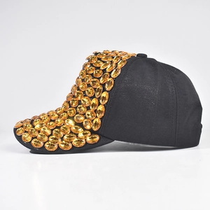 Dettaglio di strass ovali ambra incastonati su un cappello da baseball in cotone nero