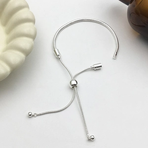 Silver adjustable snake chain bracelet with sliding clasp for DIY beads on white surface