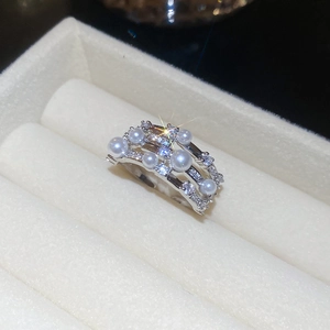 Macro view of silver multi-layer ring with white pearls and sparkling zircons in a gift box