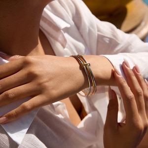 Bracelet à trois anneaux entrelacés en or et argent porté au poignet d'un mannequin