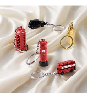 Detailed macro view of London icons keychains on elegant cream satin fabric