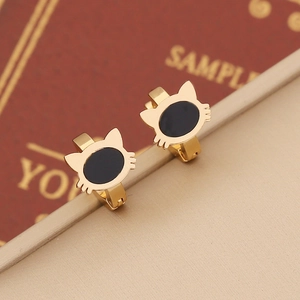 Close-up of golden cat-shaped hoop earrings with black enamel inlay on display