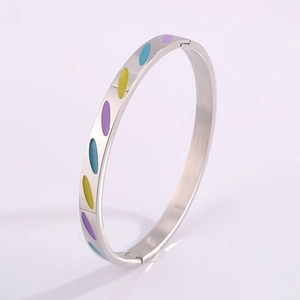 Macro detail of silver stainless steel bangle with colorful enamel oval inlay and clasp