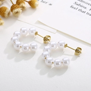 Elegant C-shaped earrings with rows of white pearls and golden metallic details
