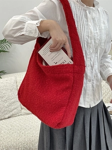 Large red fuzzy tote bag made of soft sherpa material shown on shoulder for daily use