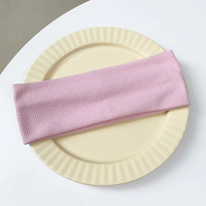 Detail showing the pink ribbed knit texture and elastic fabric of the wide headband