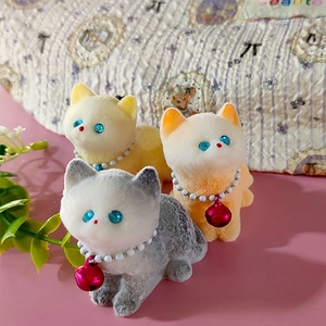 Three-piece set of flocked cat figurines with bell collars on a pink background