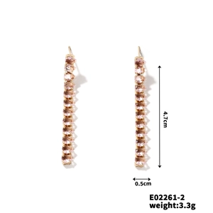 Detail view of gold earrings featuring purple baguette-cut zircon tassels with measurements