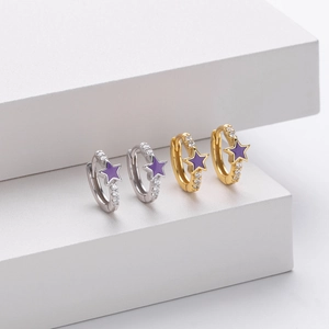 Detail of silver and gold star hoop earrings with purple enamel and white zircon stones
