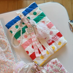 Détail d'une pochette matelassée fleurie rose avec dentelle douce et perles