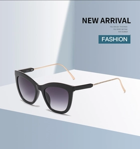 Detail of cat eye sunglasses with gold metal temples and smoky gradient lenses