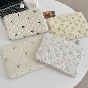 Detailed flat lay of quilted laptop sleeves in various floral and embroidered patterns