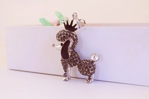 Close-up of silver puppy keychain with black rhinestones and a crown decoration