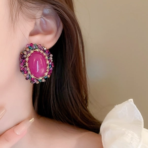 Detail of vintage oval earrings with purple faux crystal and colorful beaded accents
