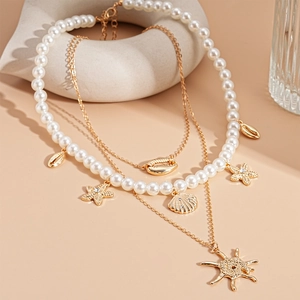 Detailed view of 3-layer necklace set with starfish, seashell pendants and white pearls