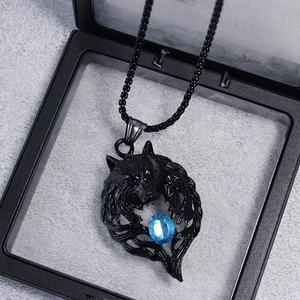 Detailed view of retro black metal wolf head pendant with blue gem in a gift box