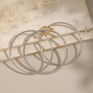 Detail of silver multi-layer stackable rings with a golden heart clasp on stone