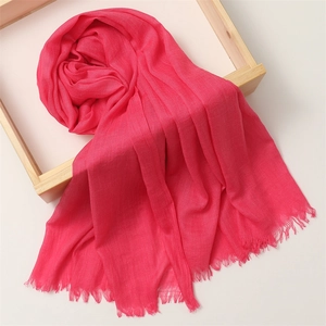 Detail of rose red cotton linen scarf showing soft texture and delicate fringe trim
